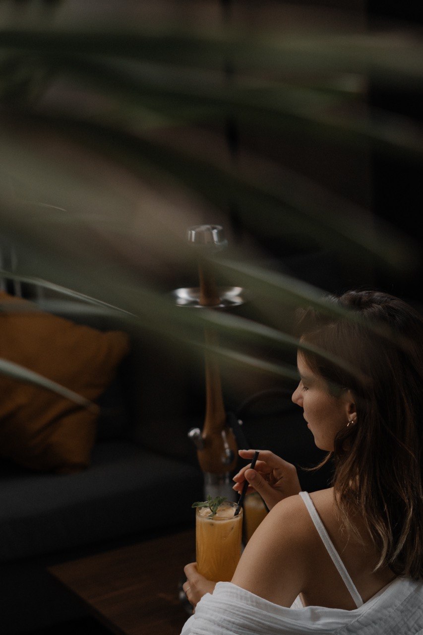 Guest enjoying a cocktail next to a hookah at Smoky Ocean