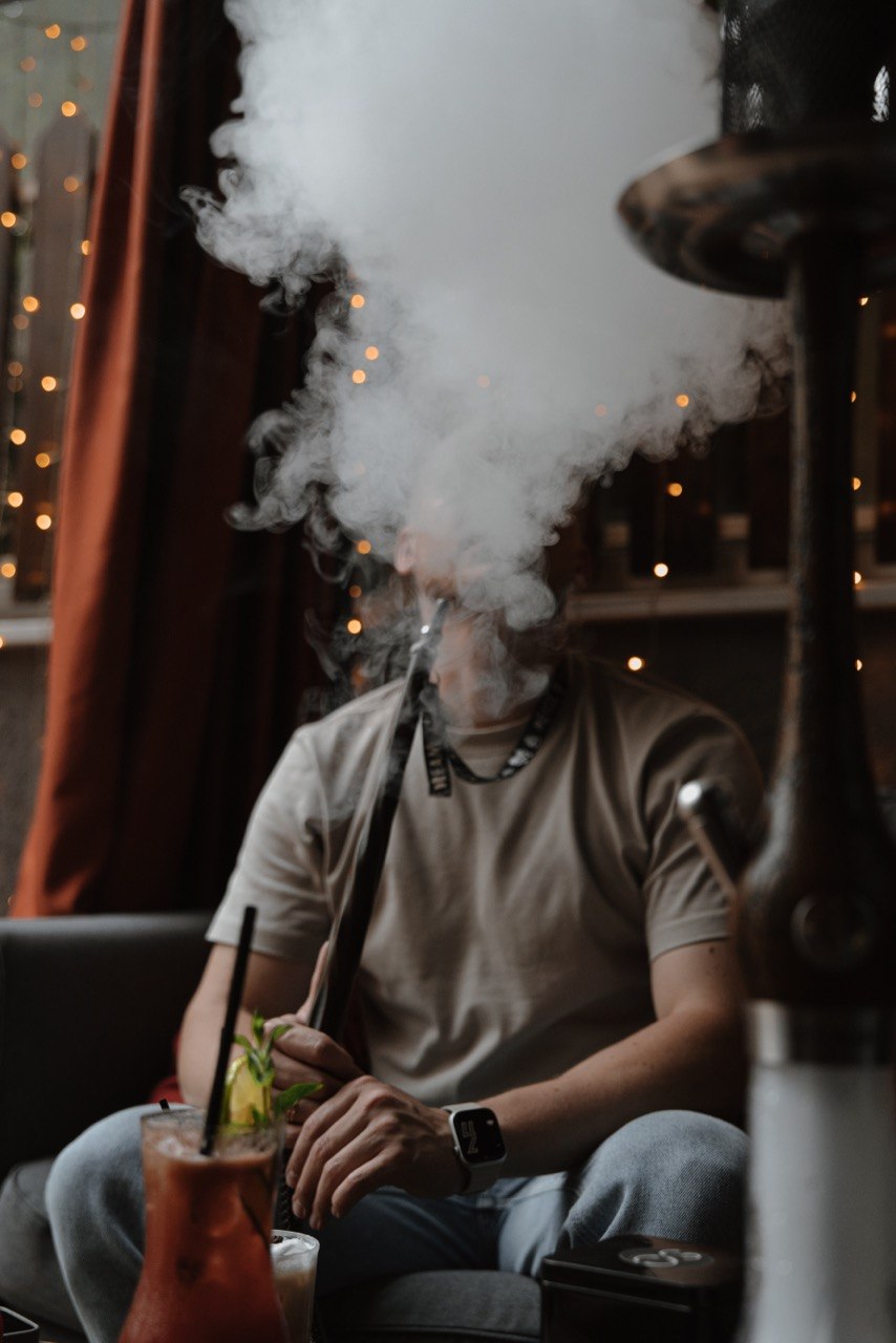 Guest exhaling a thick cloud of hookah smoke in the Smoky Ocean lounge